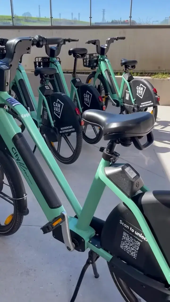 Bicis eléctricas Cityflow verdes con la marca Canvas, en fila en la residencia
